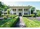 Stately two-story home featuring manicured hedges and a covered front porch with classic white columns at 711 Yadkin St, Albemarle, NC 28001