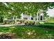 View of the home's symmetrical facade, surrounded by mature landscaping and lush greenery at 711 Yadkin St, Albemarle, NC 28001