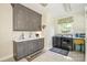 Well-equipped laundry room with gray cabinets, white countertops, and modern washer and dryer at 711 Yadkin St, Albemarle, NC 28001