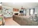 Inviting living room with brick fireplace, TV, built-in shelves, and plush gray leather sofa at 711 Yadkin St, Albemarle, NC 28001