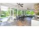 Inviting screened-in porch with tile flooring, stone fireplace, ceiling fans, and comfortable seating and table at 711 Yadkin St, Albemarle, NC 28001