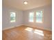 Bright bedroom featuring hardwood floors, multiple windows providing ample natural light and street views at 7645 Robinson Church Rd, Harrisburg, NC 28075