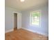 Bright bedroom featuring hardwood floors, a large window, and ample closet space for optimal storage at 7645 Robinson Church Rd, Harrisburg, NC 28075
