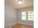 Cozy bedroom with natural light features hardwood floors and two windows overlooking the exterior at 7645 Robinson Church Rd, Harrisburg, NC 28075