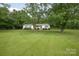 Quaint ranch-style home with lush green lawn shaded by mature trees at 7645 Robinson Church Rd, Harrisburg, NC 28075