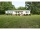 Charming single-story home with a manicured lawn, bright shutters, and a welcoming front porch at 7645 Robinson Church Rd, Harrisburg, NC 28075