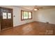 Living room with hardwood flooring, bay window, and stained glass accent on front door at 7645 Robinson Church Rd, Harrisburg, NC 28075
