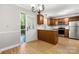 Updated kitchen with stainless steel appliances, granite countertops, and natural wood cabinets at 8266 Knights Bridge Rd, Charlotte, NC 28210
