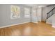 Bright living room featuring wood flooring, a staircase, and a view of the front yard at 8266 Knights Bridge Rd, Charlotte, NC 28210