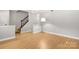 Spacious living room with wood floors, staircase, and fresh paint at 8266 Knights Bridge Rd, Charlotte, NC 28210