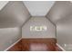 Attic space showcasing a window, with wood flooring and painted walls at 8325 Burgundy Ridge Dr, Harrisburg, NC 28075
