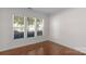 Bright bedroom with hardwood floors, neutral walls, and large windows with blinds at 8325 Burgundy Ridge Dr, Harrisburg, NC 28075