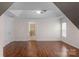 Bright bedroom with tray ceiling and wood floors, with view to bathroom and window at 8325 Burgundy Ridge Dr, Harrisburg, NC 28075
