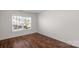 Bright bedroom featuring wood flooring, a window offering natural light, and neutral wall colors at 8325 Burgundy Ridge Dr, Harrisburg, NC 28075