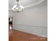 Elegant dining room with hardwood floors, wainscoting, and modern chandelier at 8325 Burgundy Ridge Dr, Harrisburg, NC 28075