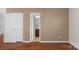 Hallway view showing a bathroom entrance, with dark wood floors and white trim at 8325 Burgundy Ridge Dr, Harrisburg, NC 28075