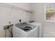 Bright laundry room with washer, dryer, wire shelving, and a window at 8325 Burgundy Ridge Dr, Harrisburg, NC 28075