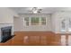 Bright living room with a fireplace, hardwood floors, ceiling fan, and lots of natural light at 8325 Burgundy Ridge Dr, Harrisburg, NC 28075