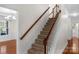 Carpeted staircase with wooden railing leading to the upper level of the home at 8325 Burgundy Ridge Dr, Harrisburg, NC 28075