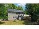 Backyard view of the home with ample green space, mature trees, and partial fencing at 8343 Highlander Ct, Charlotte, NC 28269