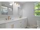 Modern bathroom with dual sinks, a white vanity, and gold fixtures at 8343 Highlander Ct, Charlotte, NC 28269