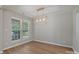 Empty dining room featuring neutral walls, wood floors and a stylish modern chandelier at 8343 Highlander Ct, Charlotte, NC 28269