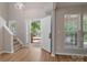 Bright foyer with hardwood floors, open staircase, and natural light from the large windows at 8343 Highlander Ct, Charlotte, NC 28269