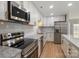 Modern kitchen with stainless steel appliances, granite countertops, and white cabinetry at 8343 Highlander Ct, Charlotte, NC 28269
