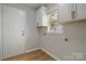 Well-lit laundry room with cabinets, window, and vinyl flooring at 8343 Highlander Ct, Charlotte, NC 28269