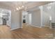 Open-concept living room with hardwood floors, leading to kitchen, and adjacent to the staircase at 8343 Highlander Ct, Charlotte, NC 28269