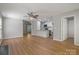 Open living room with hardwood floors, a ceiling fan and a view of the kitchen appliances at 8343 Highlander Ct, Charlotte, NC 28269