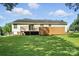 The back of the home features a wood deck and a fenced yard, surrounded by green grass at 8529 Indian Summer Trl, Harrisburg, NC 28075