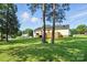 The back of the home features mature trees, a spacious yard, and fencing at 8529 Indian Summer Trl, Harrisburg, NC 28075