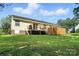 The back of the home features a wood deck and a fenced yard, surrounded by green grass at 8529 Indian Summer Trl, Harrisburg, NC 28075