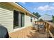 View of the wood deck with outdoor seating and a sliding door entrance under a sunny blue sky at 8529 Indian Summer Trl, Harrisburg, NC 28075