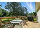 The wood deck features a glass-top table with chairs and grill, overlooking the green backyard at 8529 Indian Summer Trl, Harrisburg, NC 28075