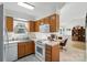 Open kitchen with wooden cabinetry, white appliances, and a view to the dining area at 8529 Indian Summer Trl, Harrisburg, NC 28075