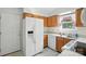 Well-lit kitchen with wooden cabinets, white appliances, and a view from the window at 8529 Indian Summer Trl, Harrisburg, NC 28075