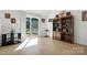 Bright living room featuring wood flooring, a bookshelf, and a sliding glass door at 8529 Indian Summer Trl, Harrisburg, NC 28075