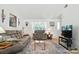 Comfortable living room with cozy seating, natural light, and a decorative area rug at 8529 Indian Summer Trl, Harrisburg, NC 28075