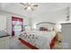 Bright main bedroom with a ceiling fan, tray ceiling, patterned bedding, and ample furniture at 8529 Indian Summer Trl, Harrisburg, NC 28075