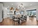 Bright open dining area with wood floors, table, chairs, and modern light fixture next to the kitchen at 1045 Waxhaw Crossing Dr, Waxhaw, NC 28173