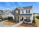 Beautiful two-story home featuring brick and gray siding with a manicured lawn, and rocking chairs on the front porch at 1045 Waxhaw Crossing Dr, Waxhaw, NC 28173