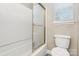 This well-lit bathroom has a white toilet and a bathtub with a partial glass enclosure at 11305 Hunters Landing Dr, Charlotte, NC 28273
