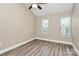 Bright bedroom featuring sleek wood flooring and two windows, perfect for a cozy retreat at 11305 Hunters Landing Dr, Charlotte, NC 28273