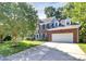 Charming two-story brick home featuring a two-car garage, dormer windows, and well-manicured landscaping at 11305 Hunters Landing Dr, Charlotte, NC 28273