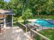 Backyard showcasing a deck and a pool and the home is surrounded by lush trees at 1134 Willow Oaks Trl, Matthews, NC 28104