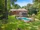 Expansive backyard featuring a pool, spa, deck, and lush landscaping at 1134 Willow Oaks Trl, Matthews, NC 28104
