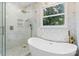 Luxurious bathroom featuring a glass shower, soaking tub, and elegant lighting at 1134 Willow Oaks Trl, Matthews, NC 28104