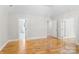 Large bedroom featuring hardwood floors, a tray ceiling, and access to the bathroom at 1134 Willow Oaks Trl, Matthews, NC 28104